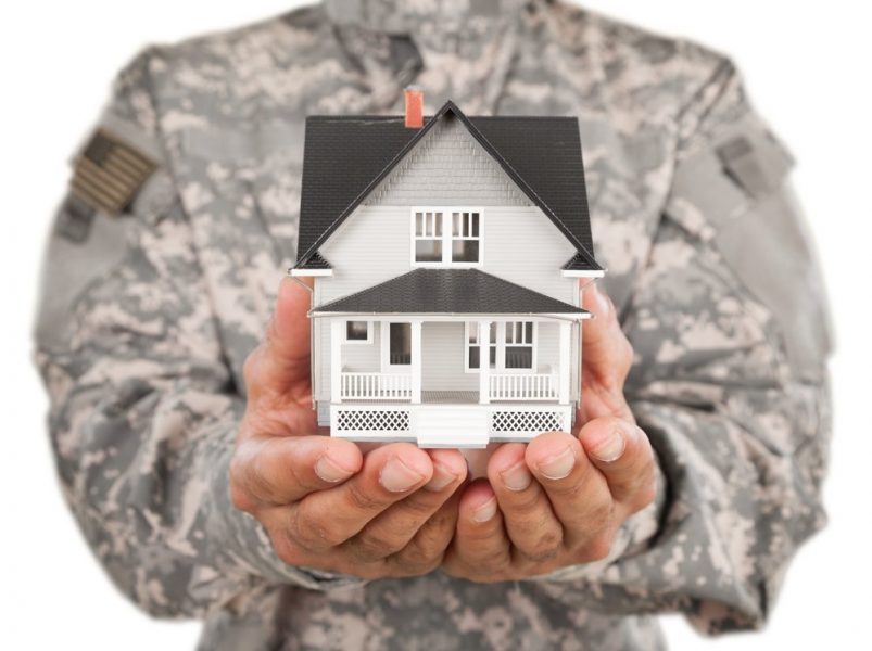 soldier holding a Model of house
